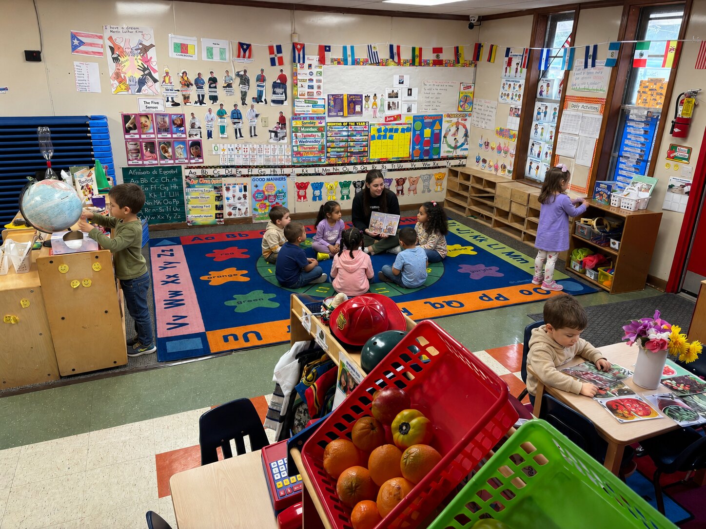 Teacher reading a story to Pre-K children on the alphabet rug at Marietta Academy in Marietta, GA